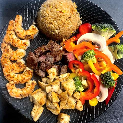 Hibachi NY strip steak, chicken and shrimp platter with fried rice and vegetables